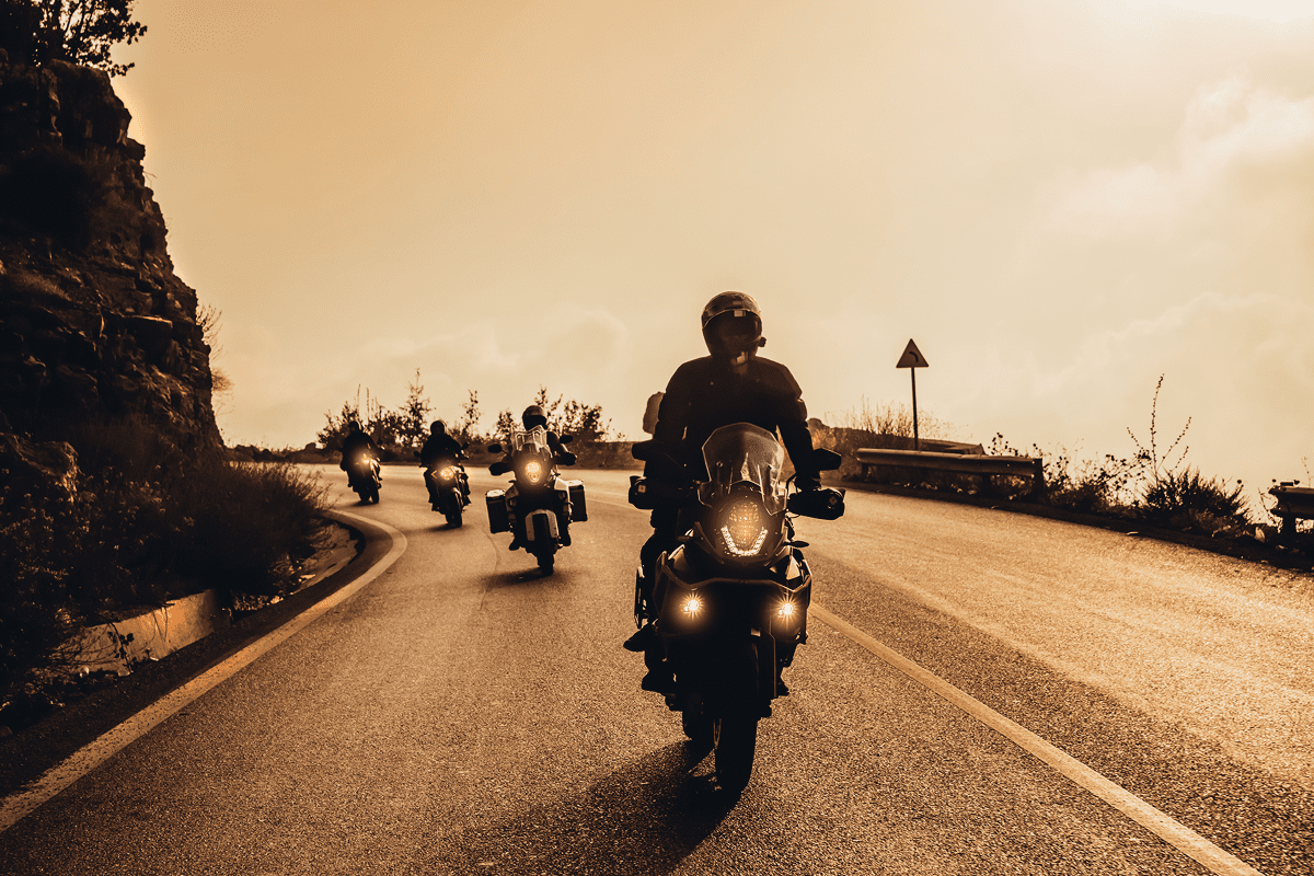 Motorcyclists riding on a scenic road.